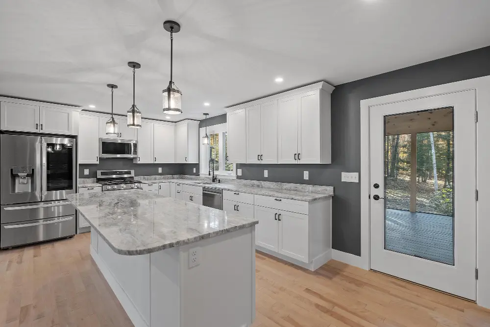 Modern kitchen renovation with marble countertops and stainless steel appliances